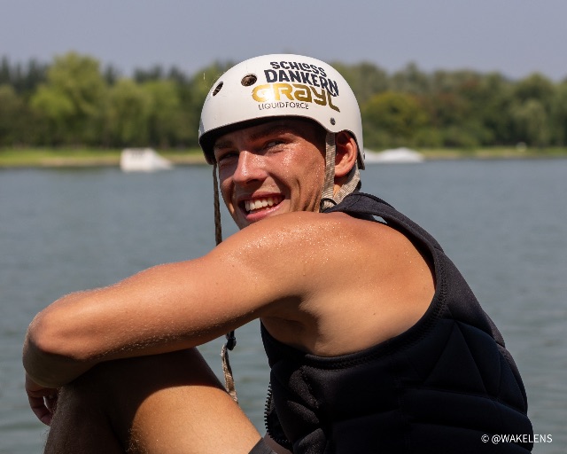 Jan-Luca Schulz in Weste und Helm am Wasser, auf dem Helm der Schriftzug seines Vereins Schloss Dankern.